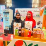 Exposantes en tablier BAGRI derrière un stand de jus locaux au Salon 100 % Made in Niger
